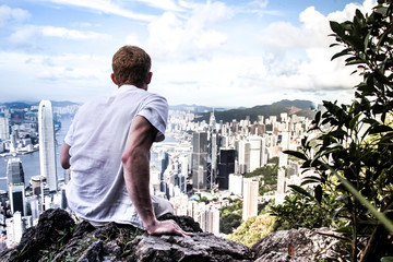 Vue homme de dos assis de la baie de Hong Kong et des grattes ciel