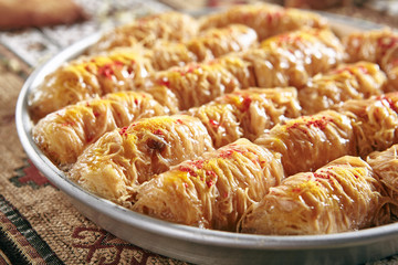 Kataifi, Kadaif or Kanafeh with Apple and Caramel on Vintage Traditional Tablecloth