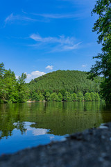Fototapeta premium Lake surrounded by mountains and forests