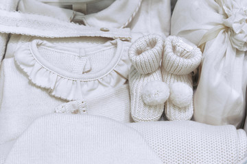 Obraz na płótnie Canvas A set of warm baby clothes in beige color for babies made from natural fabrics without the use of dyes.