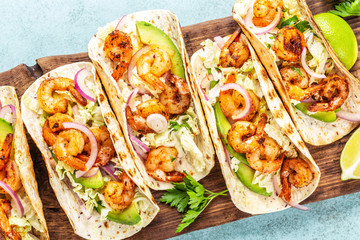 Shrimp tacos. Seafood fajitas with cabbage, onion, parsley in tortillas served on wooden cutting board - 281397910