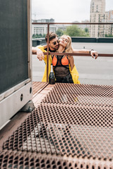 blonde woman and handsome man in glasses hugging on roof