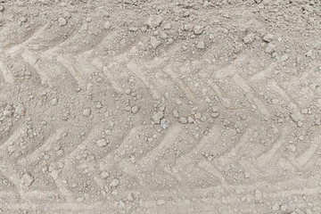 Close up Tire traces of large tractor wheels on dry ground, gray-brown