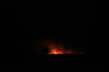 isolated bush fire blazing in the distance on a farm at night time in rural Victoria, Australia