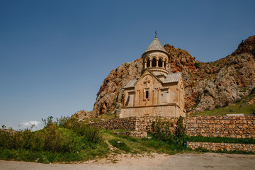 Surb Karapet church of Noravank monastery complex in Armenia built in 1216&ndash;1227 and photographed beside beautiful red cliff on a sunny summer day.