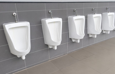 Closeup row of outdoors white urinals in the public restroom or the public toilet