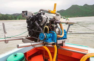 The diesel engine with accelerator and propeller of the small wooden fishing boat is parked on the...