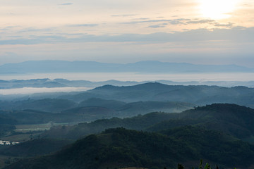 Beautiful Landscape of mountain layer in morning sun ray and winter fog full sunflowers at Doi Hua Mae Kham, Mae Salong Nai, Chiangrai, Thailand