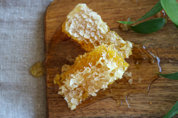 Two sweet honeycomb slices on a wooden cutting board 
