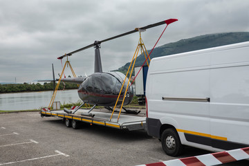 helicóptero transportado en un remolque por una furgoneta o aero taxi mediante helicóptero