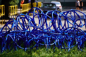 Fototapeta na wymiar the blue hose stranded in a city Park, the city landscaping, irrigation system city Park, an unusual way of twisting the hose