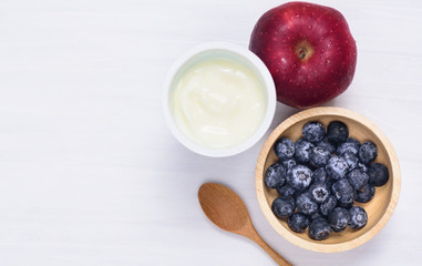 Yoghurt eating with blueberry and apple fruit on white background, healthy food