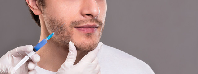 Doctor filling lifting preparation into male face