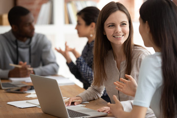 Smiling caucasian student discuss project with mate at lesson