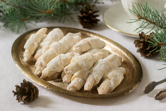 Traditional Moldavian shortcake cookies with jam stuffing and a cup of tea on the background of winter decor.