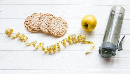 Sport photo. Healthy lifestyle. Fitness concept. Low fat crisp bread, apple and bottle of water....