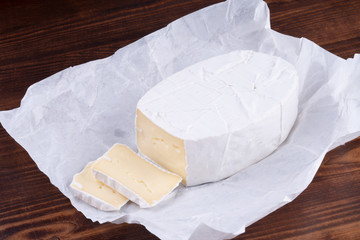 Sliced smelly camembert cheese on a wooden rustic table