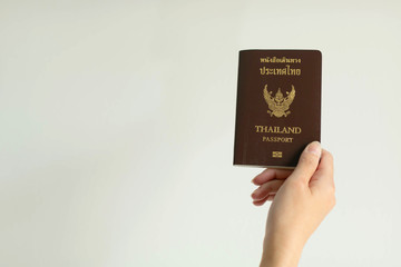 Hand showing passport of Thailand on white background.