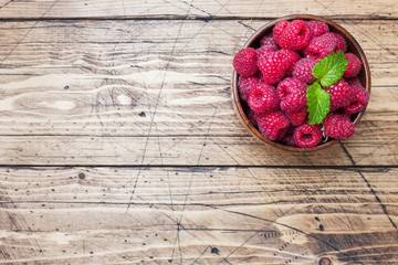 Fresh red raspberry berries in a wooden plate. © Elenglush