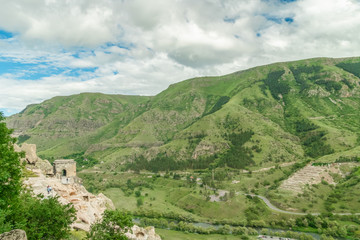 Fototapeta na wymiar Panoramic view of Vardzia cave monastery town. View from the monastery to the river valley and green slopes on a sunny summer day