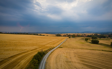 Feldweg am Getreidefeld mit Gewitter im Hintergrund