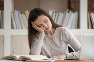 Tired girl student fall asleep studying at workplace