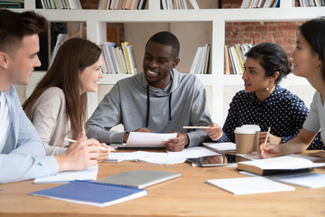 Happy multiracial young people have fun studying together
