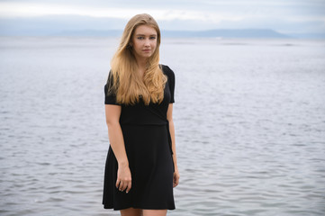 Woman in dress enjoys a walking near the sea shore.