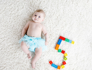 Adorable baby girl on white background wearing turquoise tutu skirt. © Irina Schmidt