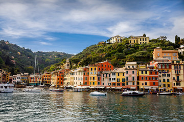 Fototapeta na wymiar Beautiful small village Portofino with colorfull houses, luxury boats and yachts in little bay harbor. Liguria, Italy. On warm brigth summer day