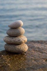Fototapeta na wymiar Zen style stones by the ocean. Tower of pebbles
