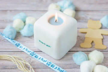 Fototapeta na wymiar white square candle gift for newborns boy or girl pastel colors blue