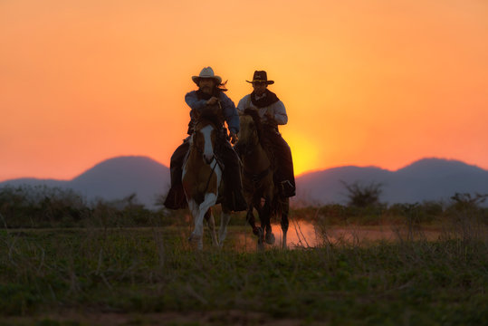 รหัสภาพถ่ายสต็อกปลอดค่าลิขสิทธิ์: 1466408231 Cowboys are riding horses silhouette in sunset with mountain scene in Pakchong, Nakhonratchasima, Thailand