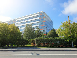 Obraz premium modern office building stands among lush green trees