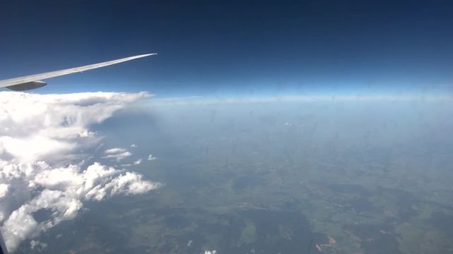 Airplane View Looking Down On Fields And Clouds