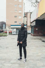portrait of young african man standing in the street and looking camera
