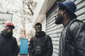 three african men standing in the street and having conversation