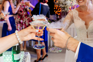 hands with glasses of champagne clink glasses at the wedding