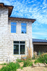 facade of cottage under construction with new inserted windows