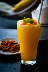 glass of smoothies juice with slice of mango