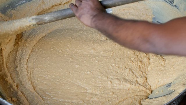 A man preparing khoya (Condensed milk) to prepare variety of sweet dishes out of it. 