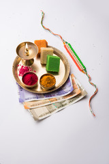 Tricolour Rakhi and Sweets for Independence Day / Raksha Bandhan which is on the Same Day in 2019, puja thali decorated with diya, haldi/kumkum and indian currency as gift