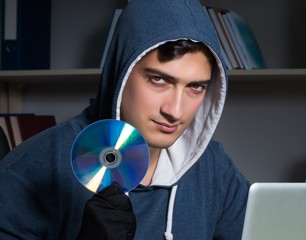 Young hacker hacking into computer at night