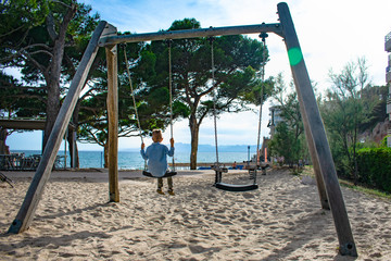 Child on a swing in the city of Salou. Spain