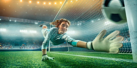 Female Soccer Goalkeeper catch the ball on a professional soccer stadium. Girls playing soccer © Alex