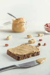 Peanut paste on brown whole grain bread. Healthy nutrition concept.