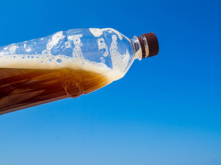 Plastic bottle of drink, beer or kvass, blue sky, global environment conservation concept