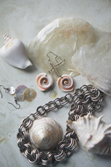 Sea collection on grey marble background.Seashell and mother-of-pearl earrings. Summer...