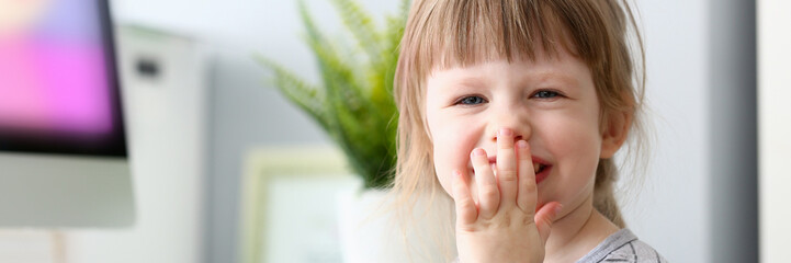 Little happy baby girl laughing covering mouth