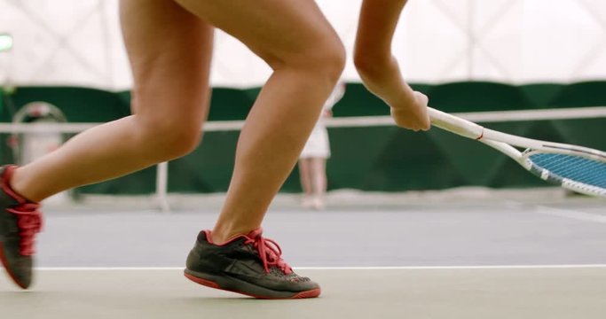 CU Young Caucasian female tennis player hitting a ball during a game or practice. 120 FPS slow motion, 4K UHD RAW graded footage